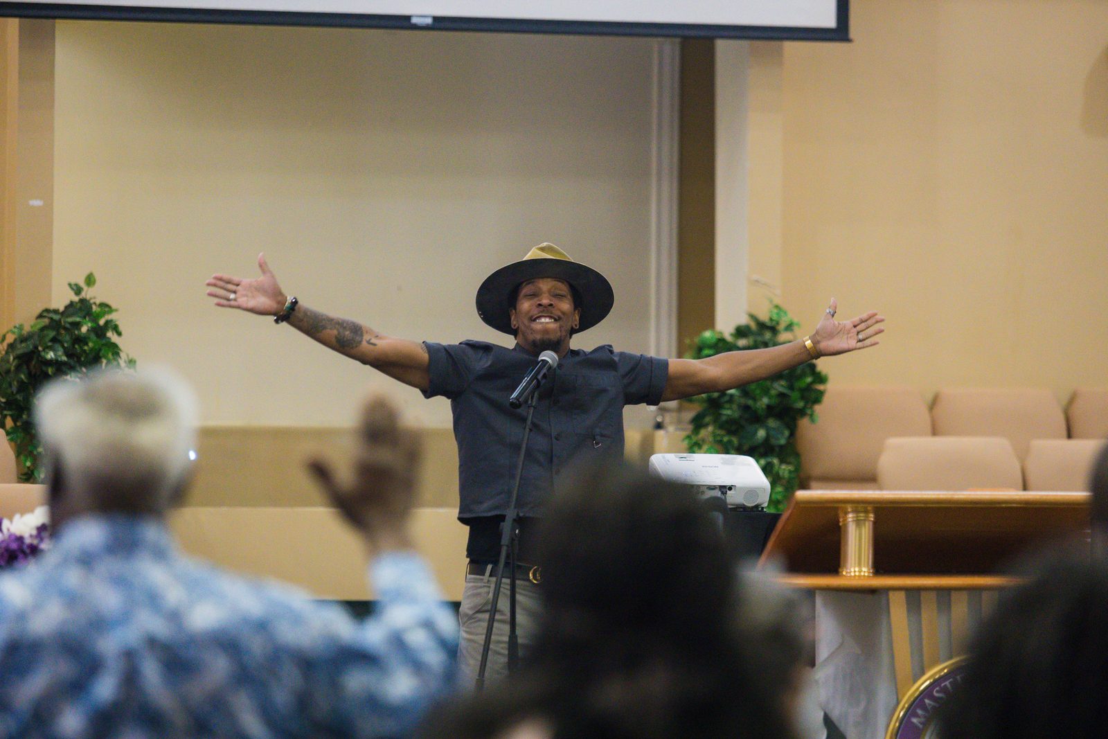 Gospel artist leading worship with arms wide