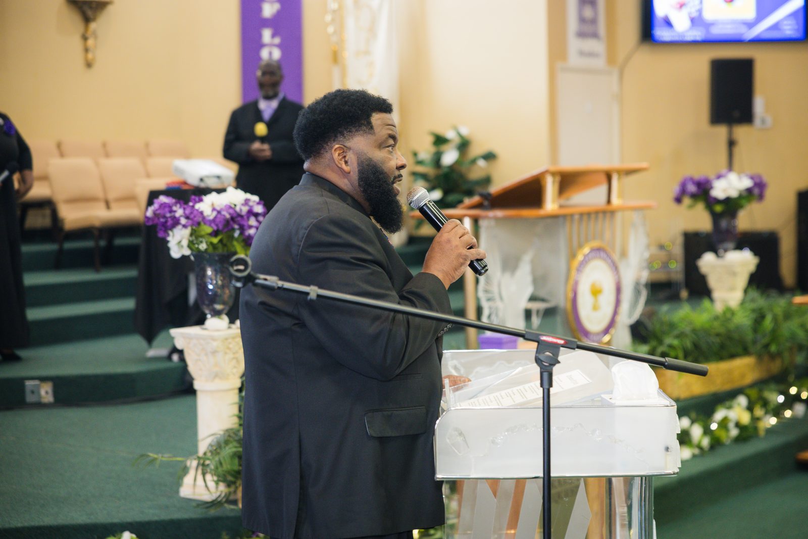 Pastor preaching with the choir behind him