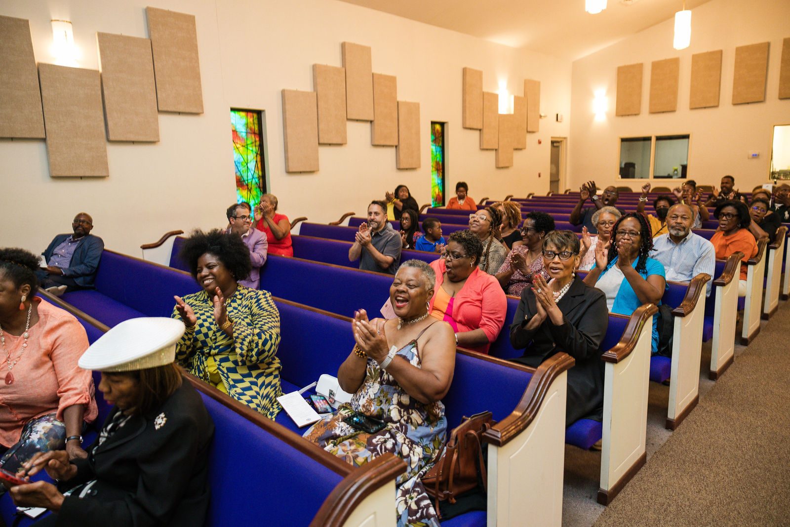 Congregation clapping in purple pews