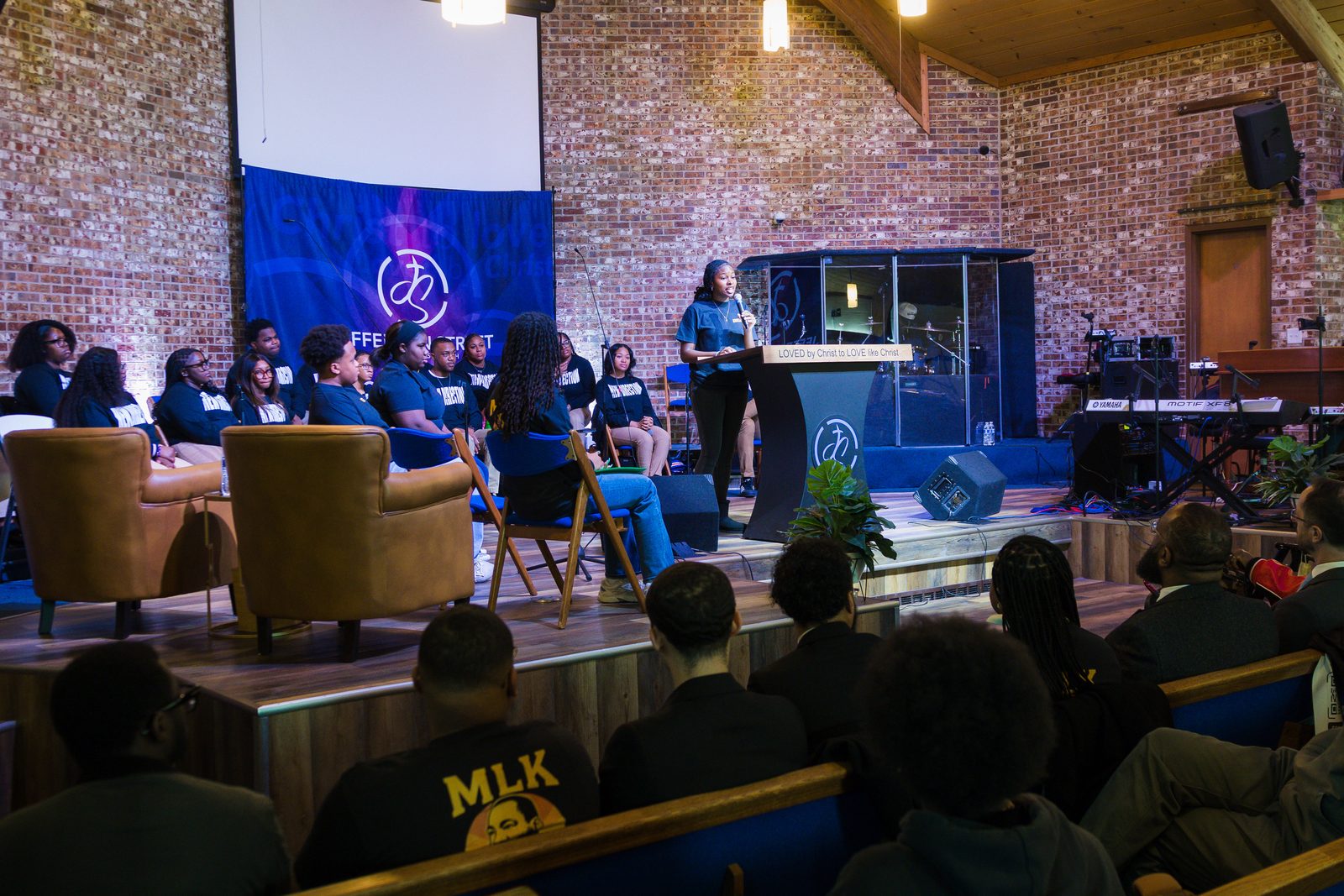 Youth gathered in a brick sanctuary