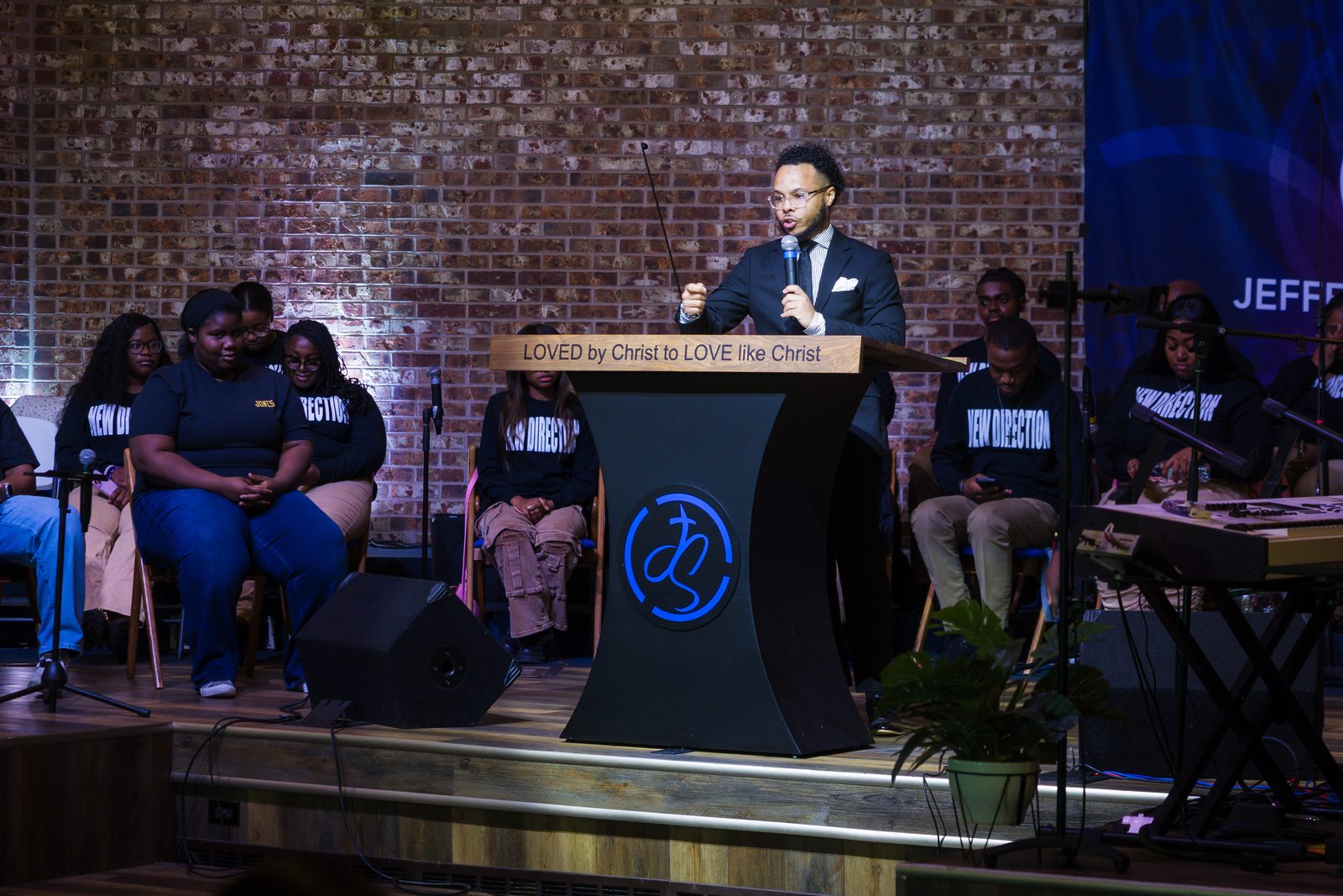 Minister at the pulpit with the youth choir behind him