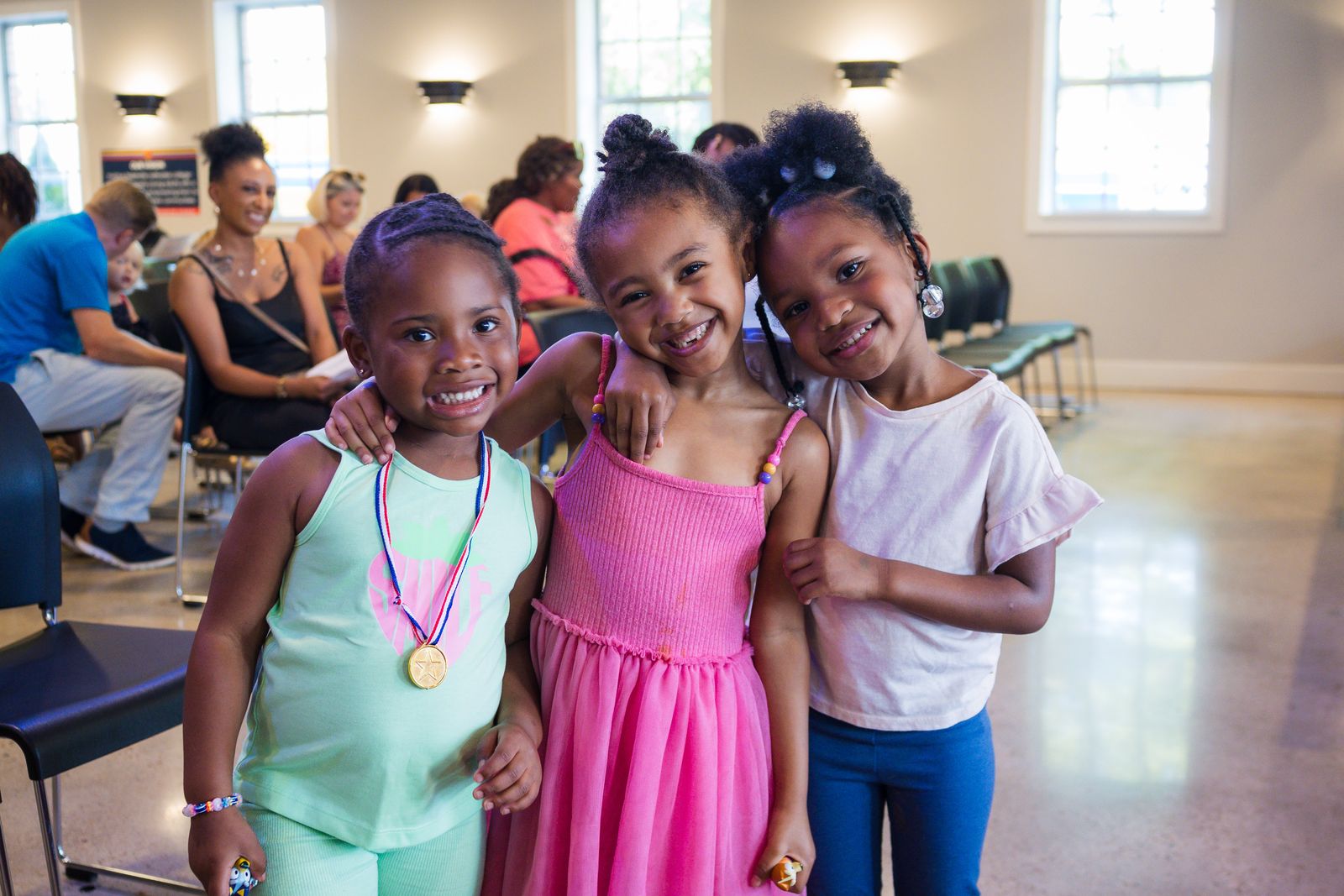 Three young students smiling at a family info session