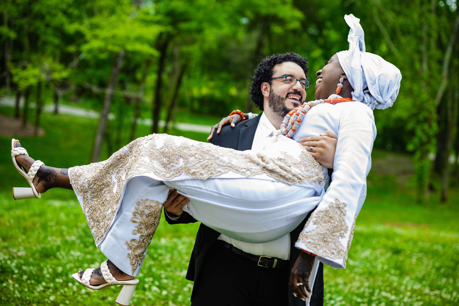Mazen carries Aisha across the lawn