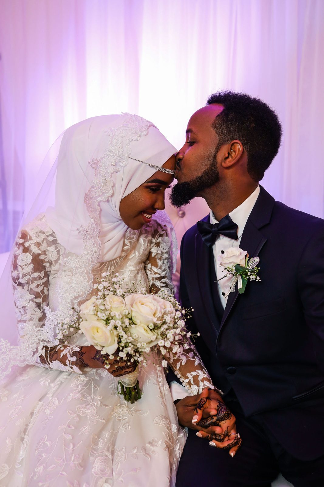 Groom kisses the bride on the forehead