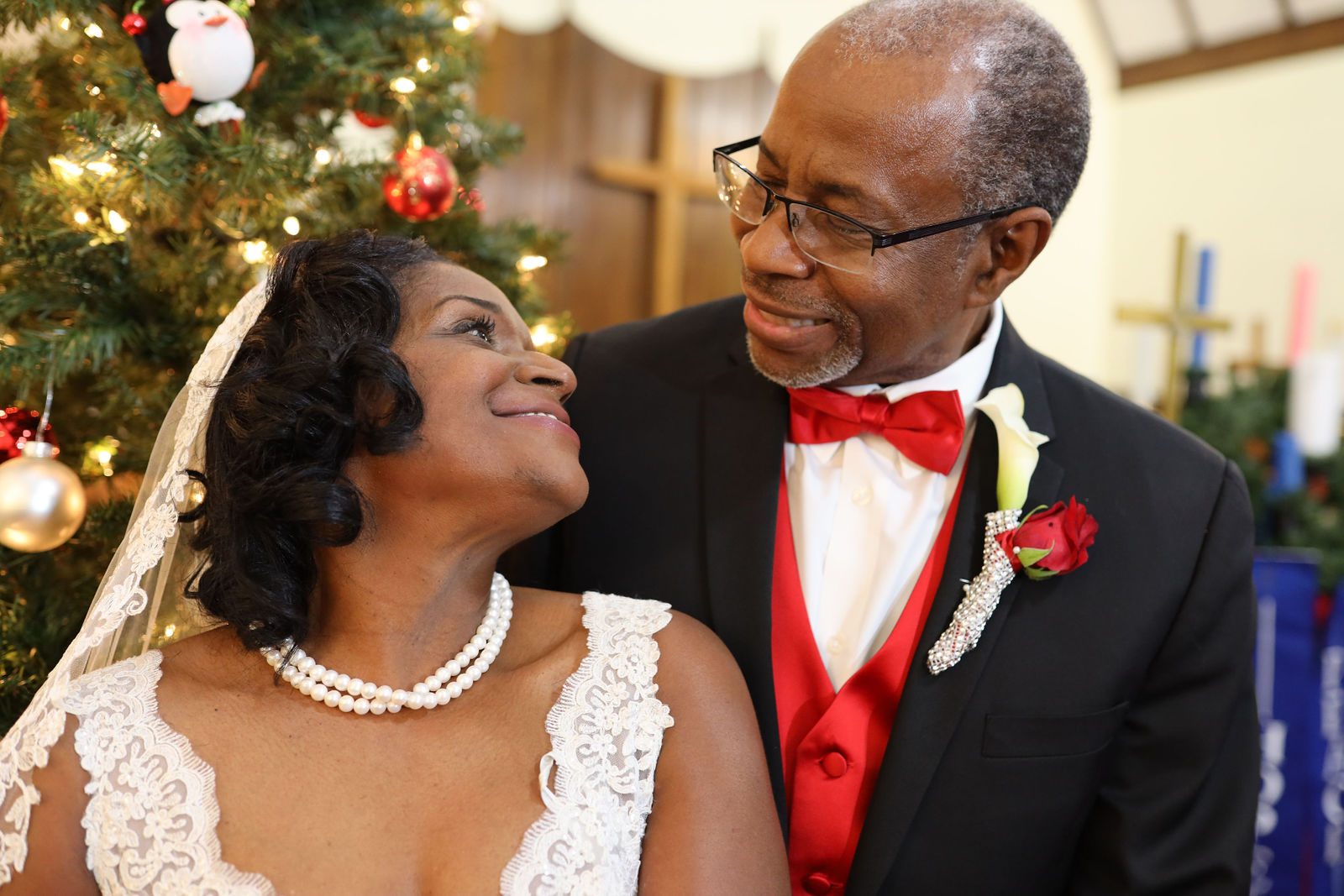 Bride and groom smiling by the Christmas tree