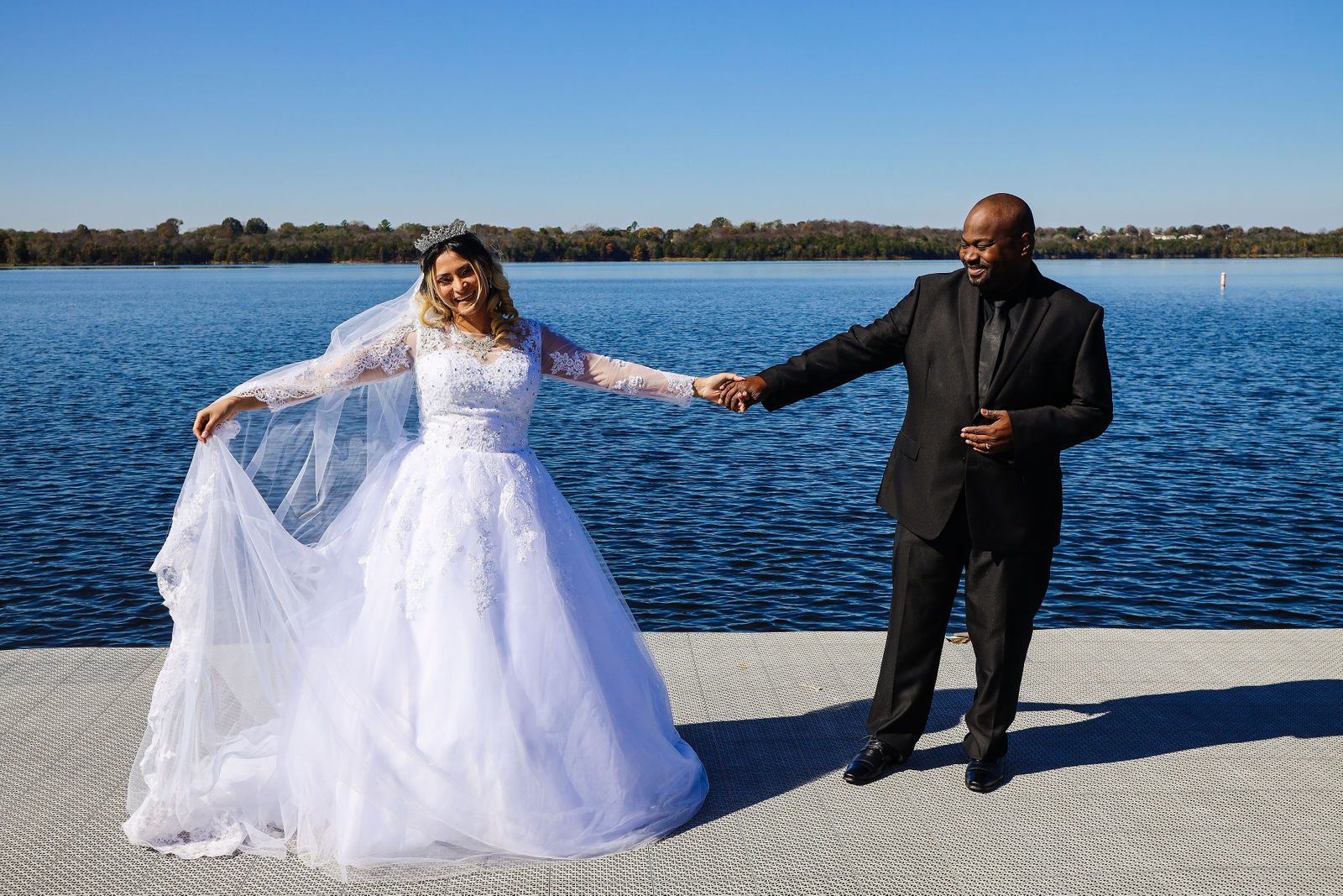 Bride spreading her veil on the dock with the groom