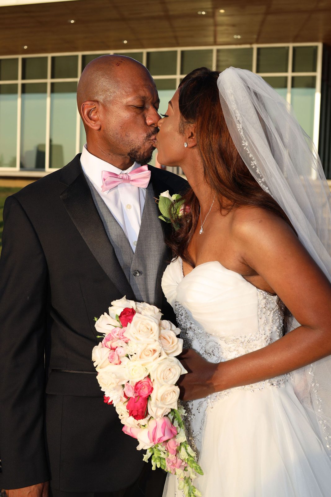 Bride and groom kiss outside the venue